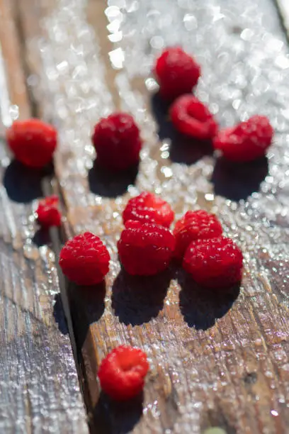 close up raspberries on wood surface