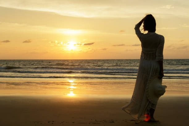 istock Woman on the beach during sunset time 1005459152