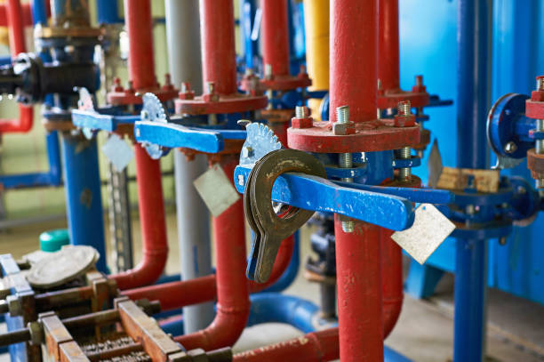 la valvola blu sulla tubazione dell'acqua calda è dipinta di rosso. contesto industriale. - giant boilers foto e immagini stock