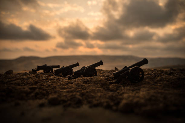 War Concept. Old artillery cannon guns on war fog sky background. Selective focus
