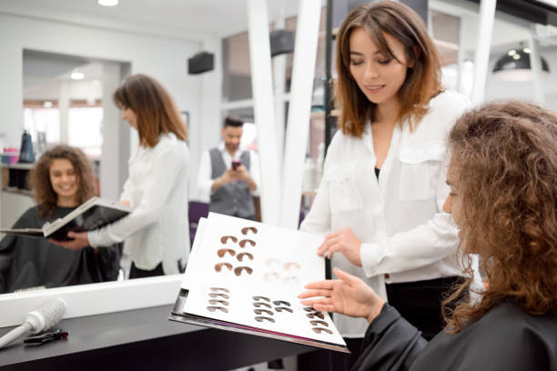 istock Curly female client picking a color for hait toning in beaty salone. 1005463460