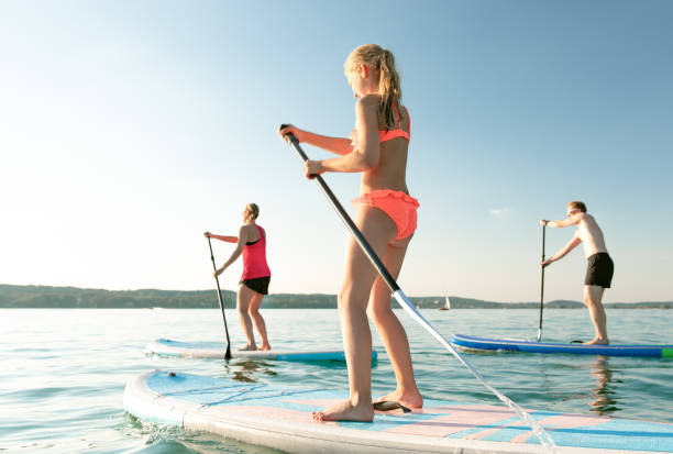 yoga su un sup - lake summer beach nautical vessel foto e immagini stock