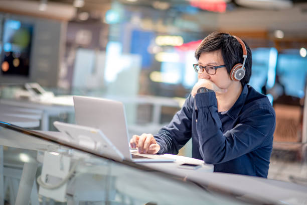 istock Young Asian business man feeling stressed and frustrated while working with laptop computer. Male entrepreneur getting in trouble with his job. freelance lifestyle in urban workspace. 1005480940