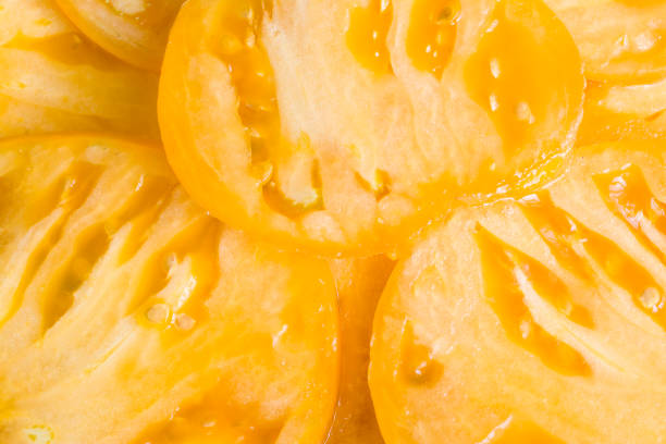 istock organic tomato slice, yellow food backround 1005490040
