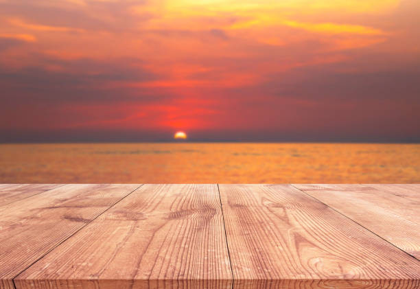 istock Empty wood table with beautiful sunset beach over the sea 1005490140