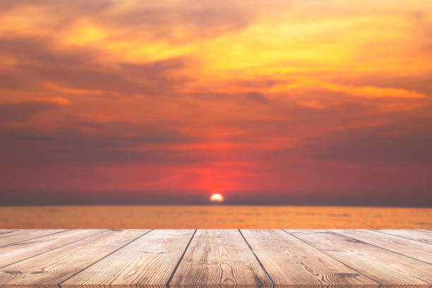 istock Empty wood table with beautiful sunset beach over the sea 1005490144
