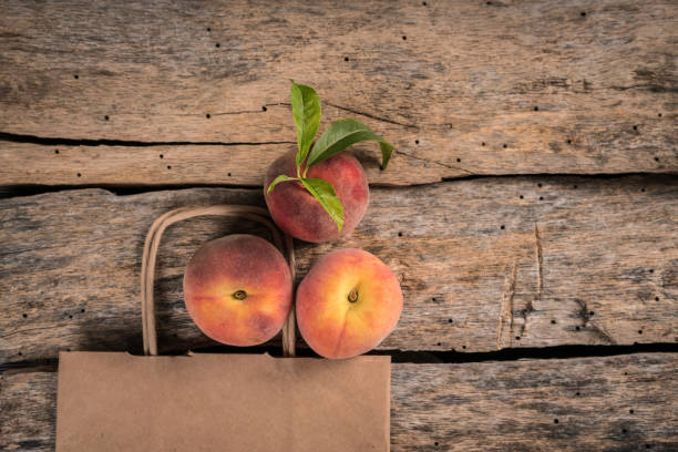 Sweet peach in  in shopping bag on rustic grey wooden table