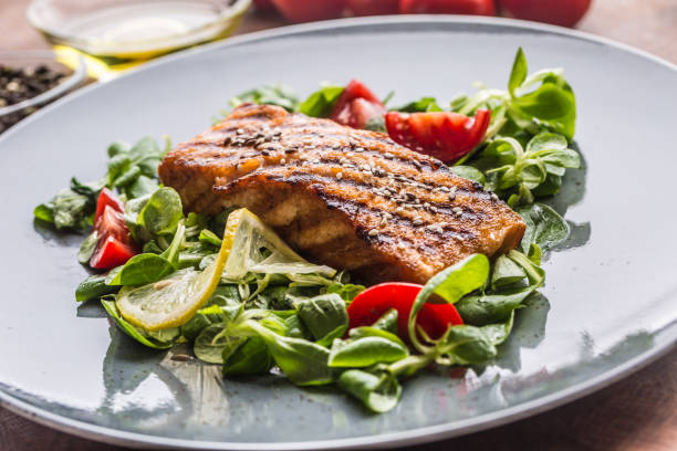 istock Grilled  salmon fillet with salad tomatoes and sesame. 1005502002