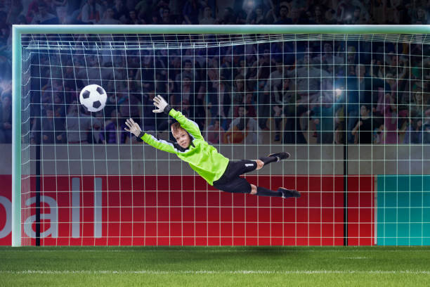 istock goalkeeper kid saving in jump on a crowded stadium 1005508000