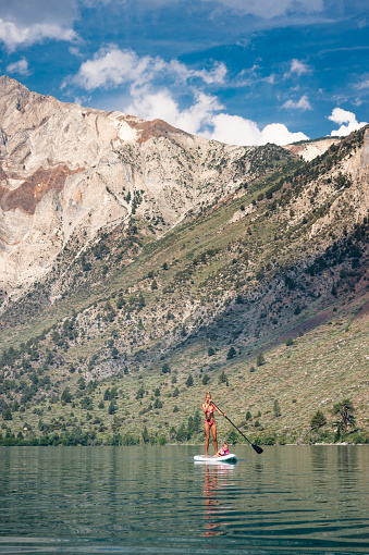 Woman and Daughter Paddle Boarding In The Mountains