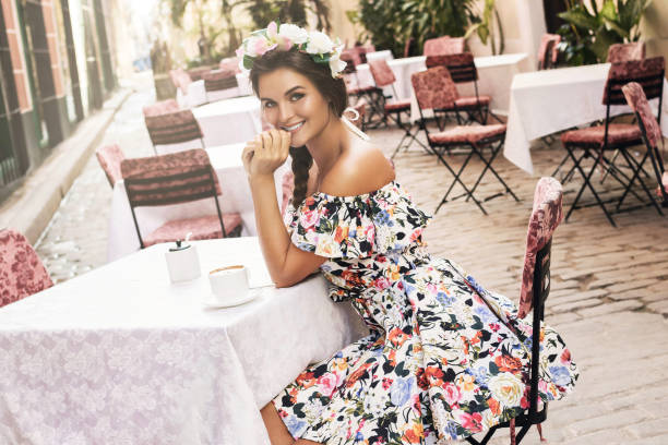 istock Smiling woman sitting in the stree cafe 1005513516