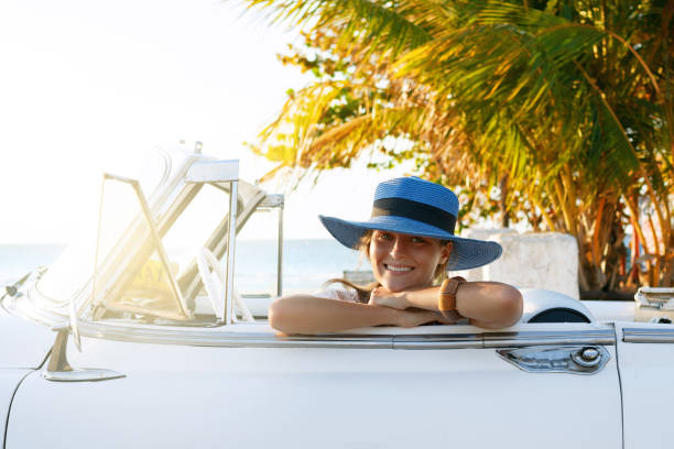 istock Beautiful woman in blue hat and white retro cabriolet 1005516170