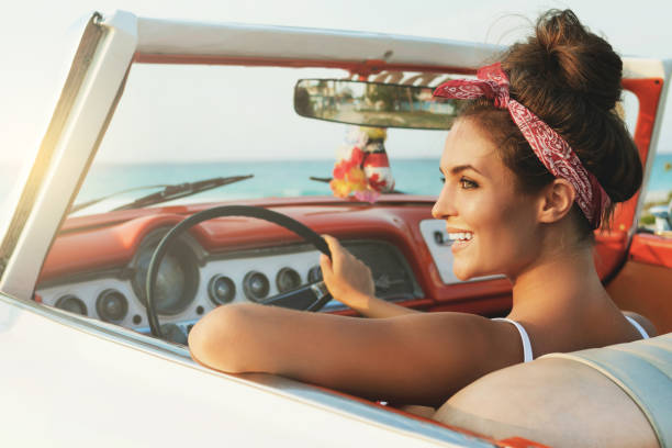 istock Beautiful and happy woman inside a retro car 1005517040
