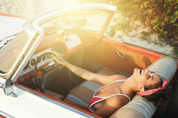 istock Beautiful and happy woman inside a retro car 1005517142