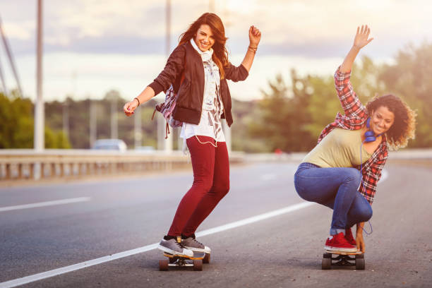 istock Skateboard girls riding longboards down the road 1005520738