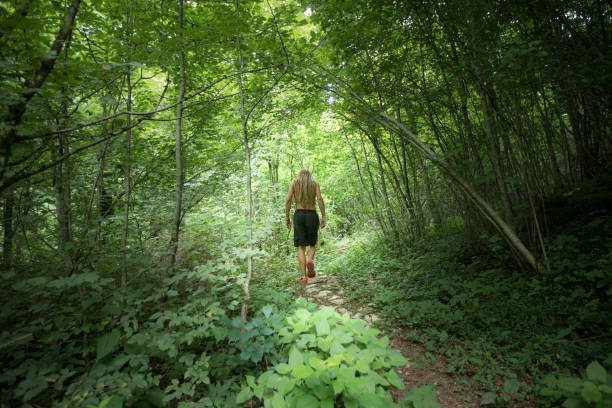 istock Young Rastafarian Man Walking Shirtless Thru Forest 1005524328