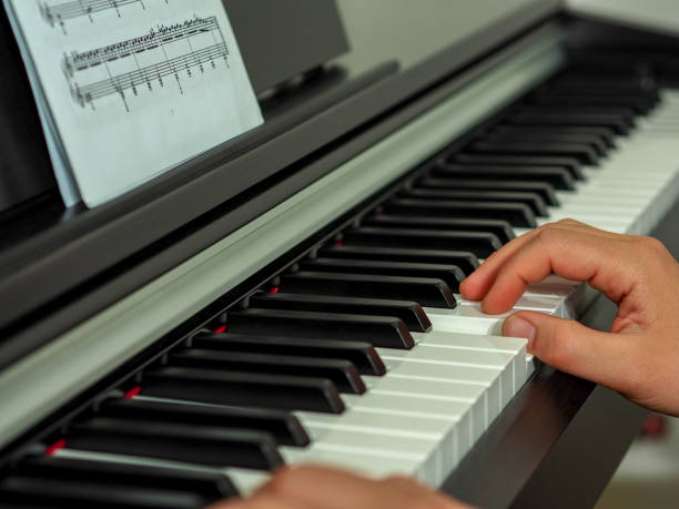 istock close-up black and white piano keys and piano playing hands 1005529584