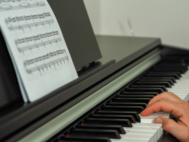 istock close-up black and white piano keys and piano playing hands 1005529618