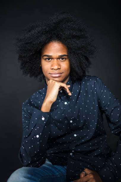 istock Young afro male sitting with hand on chin 1005535148