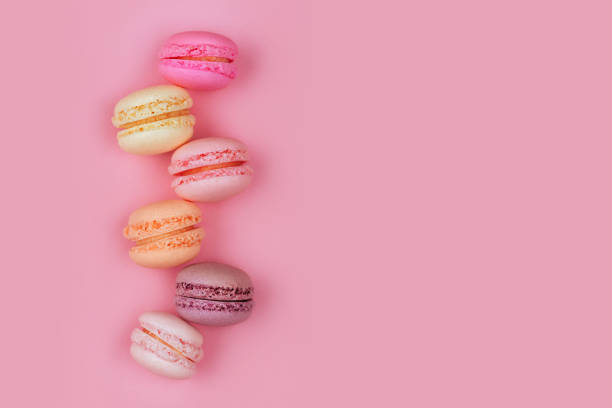 istock Top view of colorful macaron or macaroon on pink background. 1005549984