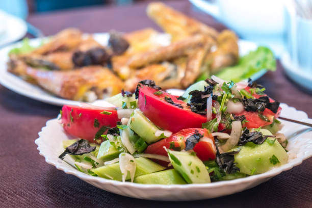 istock Tomato and cucumber salad with onion, pepper and parsly 1005561832