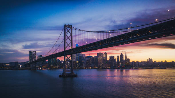 Aerial Cityscape view of San Francisco and the Bay Bridge with Colorful Sunset Aerial Cityscape view of San Francisco and the Bay Bridge with Colorful Sunset, California, USA san francisco county city california urban scene stock pictures, royalty-free photos & images