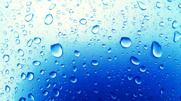 istock Water Drops background on the Blue glossy surface, Rain droplets on blue texture for cosmetics, drink product. 1005589842