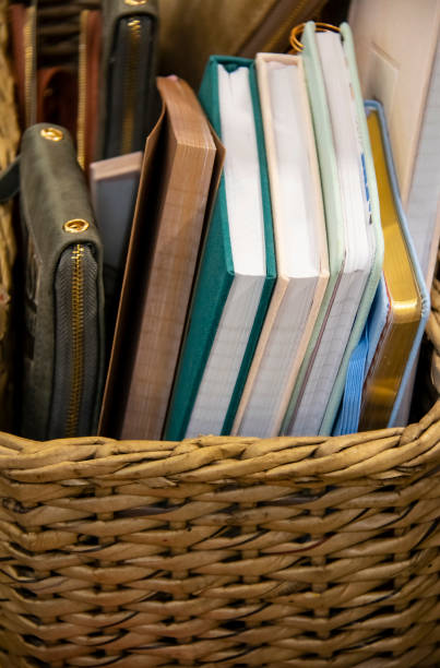 istock Assorted notebooks or books plus a notepad in a zip up cover in a woven basket 1005593198