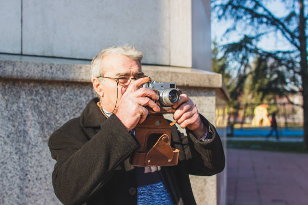 istock Senior Adult Man with Old Fashioned Camera 1005598932