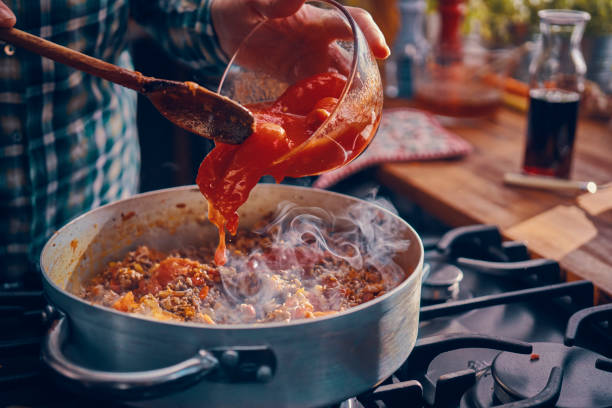 Preparing Homemade Spaghetti Bolognese Preparing Homemade Spaghetti Bolognese in Domestic Kitchen savory sauce stock pictures, royalty-free photos & images