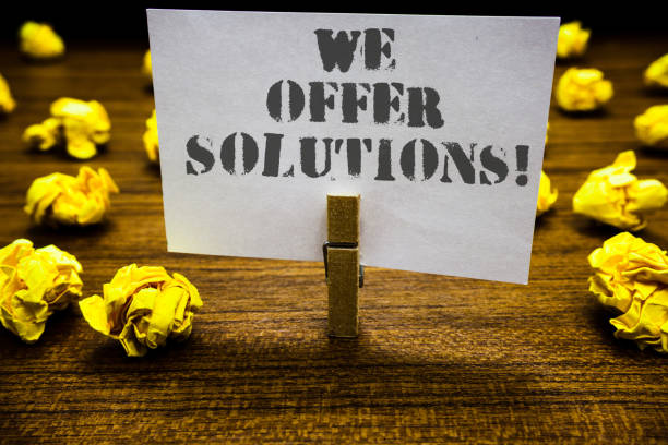 istock Text sign showing We Offer Solutions. Conceptual photo Offering help assistance Experts advice strategies ideas Paperclip grip white page with grey text woody floor laid blurry yellow lob. 1005607914