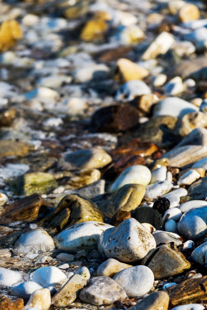 istock Pebble stones and with wave on background in beach, Greece 1005624830