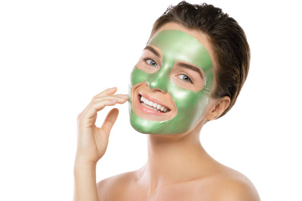 istock Woman with green peel-off mask on her face 1005625050