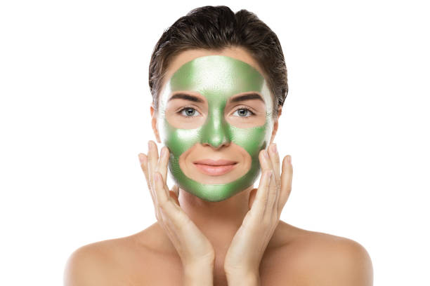 istock Woman with green peel-off mask on her face 1005627548