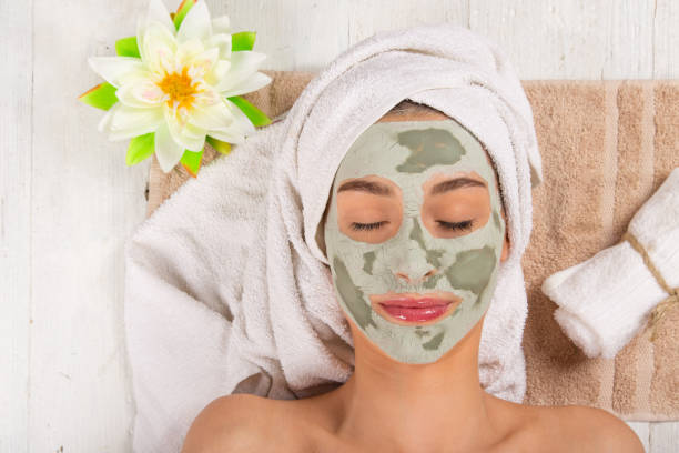 Young healthy woman with face mask Young healthy woman in spa making treatments and face mask. green clay stock pictures, royalty-free photos & images