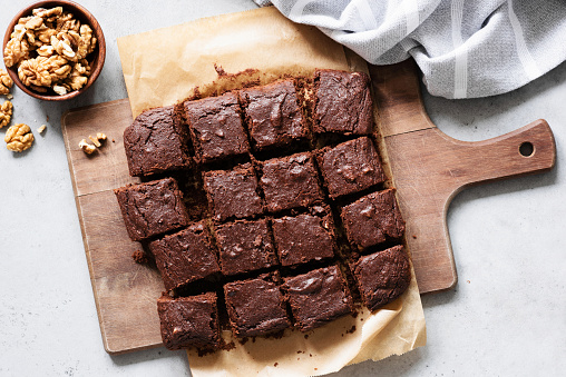 Cuadrados de brownie de chocolate en tabla de cortar, vista superior photo