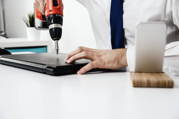 istock Upset and furious man spoils the laptop using a screwdriver. 1005636736