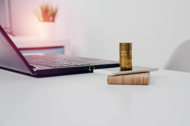 istock Gold coins are on the phone. 1005641210