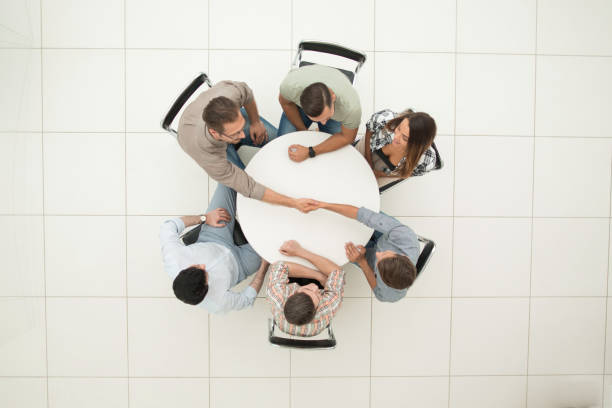 top view. handshake colleagues at the round table