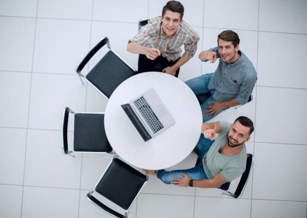 istock top view.creative team pointing fingers at you 1005644390