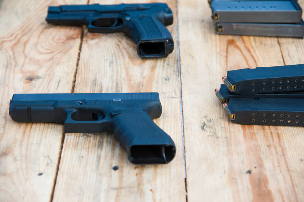 istock Gun with ammunition on wooden background 1005644432