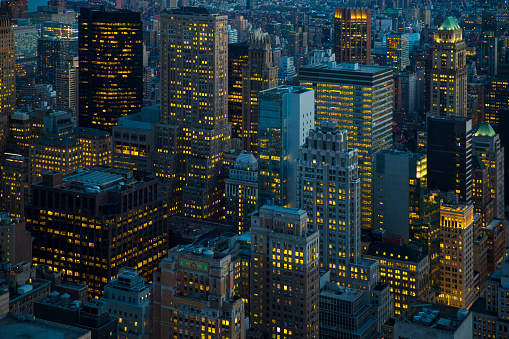 A high angle view at dusk across multiple office and apartment buildings in Manhattan, New York City.
