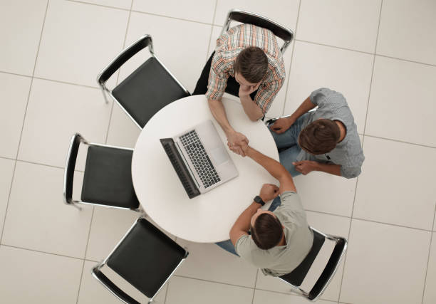 istock group of people with gadgets sitting at a round table 1005644462