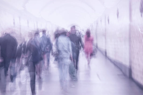 istock Unrecognizable group of walking people in subway station. Blurred abstract background, violet shades 1005651916