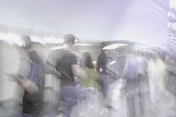 istock Abstract unrecognizable group of hurried passengers in subway station. Blurred motion background, violet shades 1005651928
