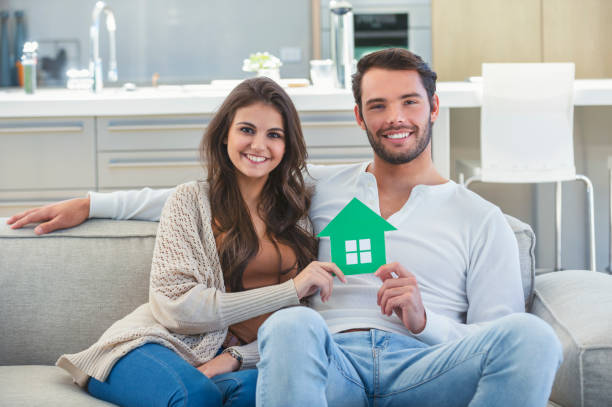 istock Couple holding a cardboard home icon. 1005667330