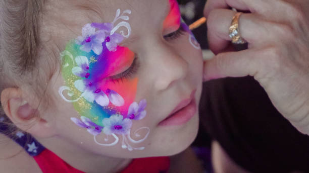 istock Little girl getting her face painted at the carnaval. 1005668038
