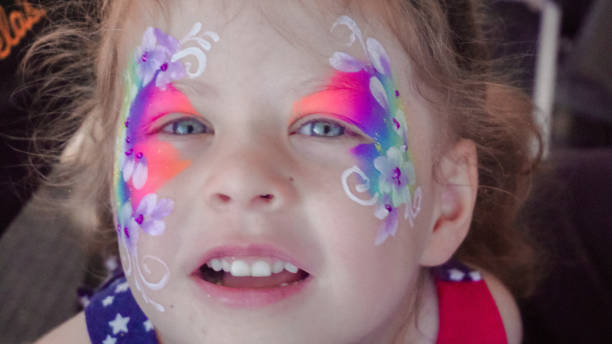 istock Little girl getting her face painted at the carnaval. 1005668046