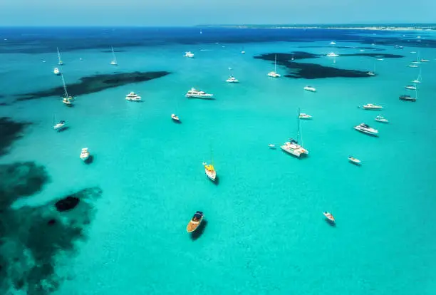 Photo of Aerial view of boats, luxury yachts and transparent sea at sunny day in Mallorca, Spain. Colorful summer landscape with marina bay, blue water, sandy beach, sky. Balearic islands. Top view. Travel