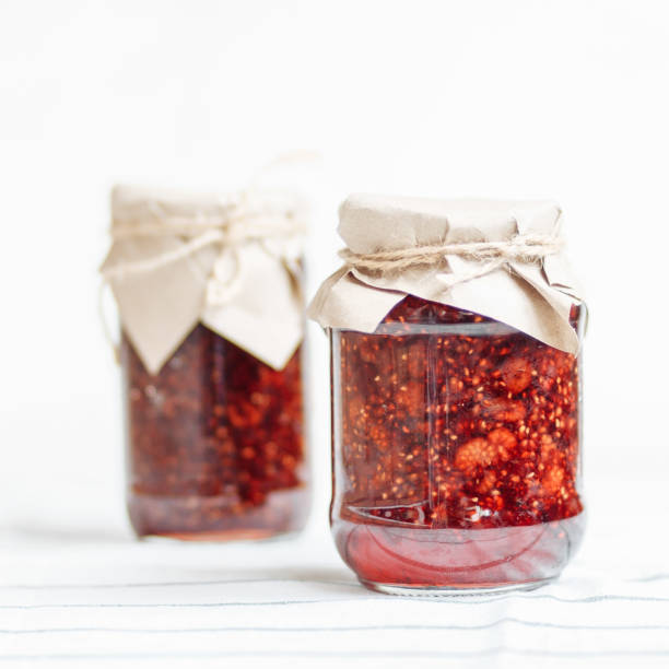 istock glass jars with raspberry jam on a wooden table, home-made preparations, cooking, homemade desserts 1005697852